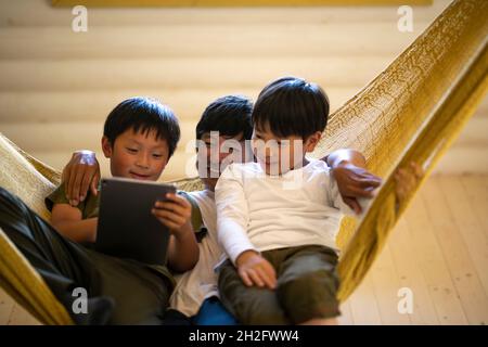 Father and Sons Relaxing in Hammock Stock Photo