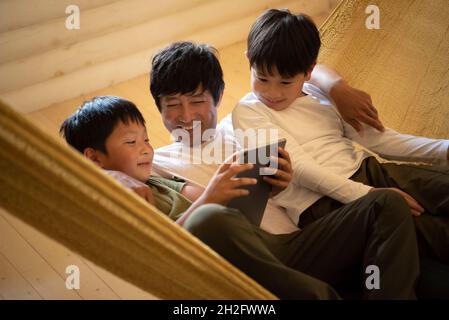 Father and Sons Relaxing in Hammock Stock Photo