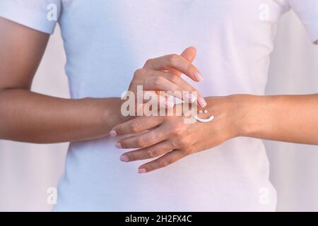 Woman applying hand cream, protective cream or moisturizer. Hand skin protection. Hand care or skin care concept. Beautiful woman hands with cream Stock Photo