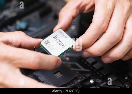 Close up of electronic engineer installing Ryzan microprocessor. Maintenance computer cpu hardware. Hand holding computer processor chip. Concept of c Stock Photo