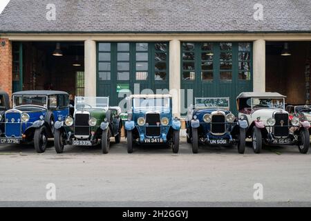 Vintage Alvis cars outside a workshop at the Bicester Heritage Centre super scramble event. Bicester, Oxfordshire, England Stock Photo