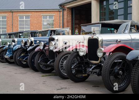 Vintage Alvis cars outside a workshop at the Bicester Heritage Centre super scramble event. Bicester, Oxfordshire, England Stock Photo