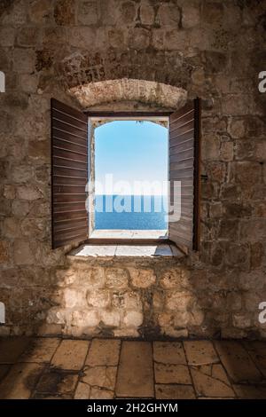 Sunlight shines through the open window overlooking the sea. Stock Photo