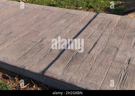 stamped concrete pavement outdoor with expansion joint working, Wooden slats pattern, flooring exterior, decorative cement paving with streaks Stock Photo