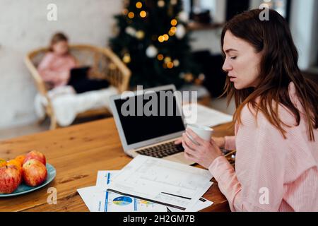 Young woman working in the kitchen at home during the winter vacations. Stock Photo