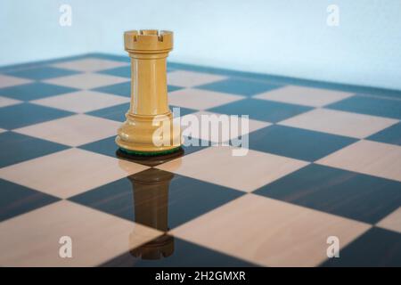 White rook on a chess board. Chess piece. Stock Photo