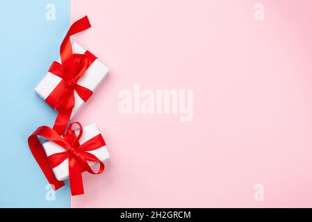 Valentines day greeting card template. Gift boxes over blue and pink background. Top view flat lay with copy space Stock Photo