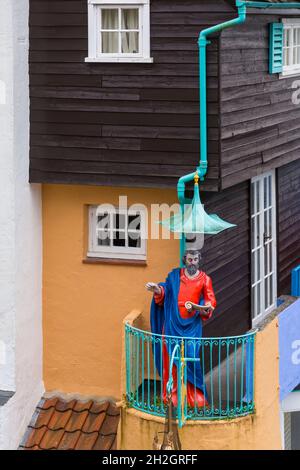 Portmeirion village, Gwynedd, North Wales - statue of St Peter preaching on balcony of Toll House - tourist village Stock Photo
