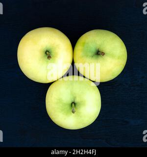 Ripe juicy yellow-green apples on a wood background Stock Photo