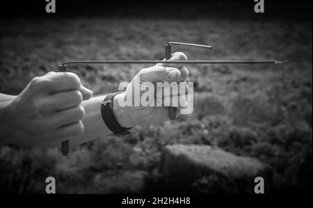 Dowsing rods being used at a stone circle, looking for ley lines. Stock Photo