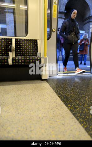 London, England, UK. Woman getting on a tube train Stock Photo