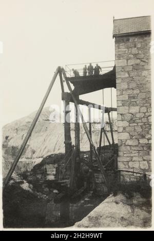Bloomdale China Clay and Stone Works, St Stephen-in-Brannel, Cornwall, 1919-1936. Men on the gantry outside the engine house from which the slurry pump is operated, at Bloomdale China Clay and Stone Works. This photograph forms part of a set within the album documenting the china clay industry of Cornwall, particularly focusing on the area around St Austell. China clay - also called kaolin - was used to make porcelain. The china clay industry was one of the main extractive industries in Cornwall. The images are accompanied by handwritten notes and descriptions of the processes involved in the Stock Photo