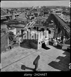 Castle Keep, Castle Garth, Newcastle Upon Tyne, c1955-c1980. A cityscape of Newcastle, looking south over the River Tyne from the roof of Castle Garth Keep. The keep was built between 1168 and 1178, with the roof and battlements added c1811 by Newcastle Corporation. It was later restored c1848 for the Society of Antiquaries of Newcastle. The tower is square in plan with three storeys. In the foreground is the River Tyne, with the Tyne Bridge on the left, Swing Bridge, and High Level Bridge on the right. The image continues looking south. Stock Photo