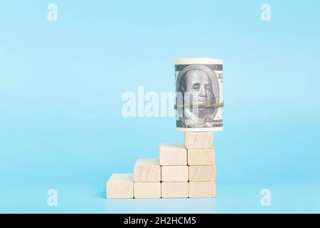 Dollars on the on economic growth on a blue background. International currency and money of the USA. Investment, income, capital, banking, profit and business concept. High quality photo Stock Photo
