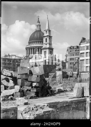 St Paul's Cathedral, St Paul's Churchyard, City of London, City and County of the City of London, Greater London Authority, 1941-1945. A view looking south-west across a bomb damaged landscape towards the Church of St Vedast-alias-Foster with St Paul's Cathedral beyond. The Church of St Vedast-alias-Foster was rebuilt by Christopher Wren after the Great Fire of London in 1666. In the Second World War it was gutted by fire during the Blitz in 1940-41 and was later rebuilt after the war with work starting in 1953. St Paul's Cathedral survived the bombing raids but other buildings in the area wer Stock Photo