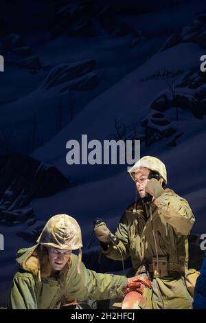 Two soldiers, one wounded, call for help in the snowy mountains during a cold winter of the Korean War. At the National Museum of the Marine Corps Her Stock Photo