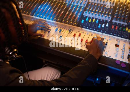 Close-up of producer creating a new song using electric music keyboard in the studio Stock Photo