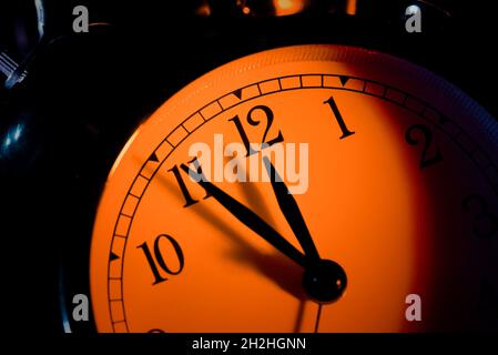 Five minutes to midnight. Changing the clocks, time adjustment, daylight savings or new year concept on retro analog clock, close up Stock Photo