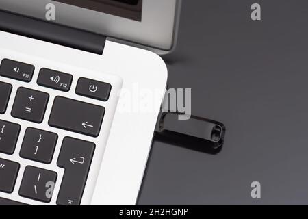 USB flash drive connected to the laptop's USB socket. Pen drive, flash memory concept Stock Photo