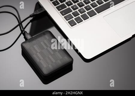 External backup disk hard drive connected to laptop Stock Photo