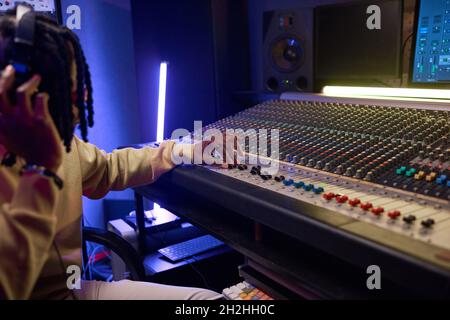 Sound operator in audio recording studio using music keyboard to create songs Stock Photo