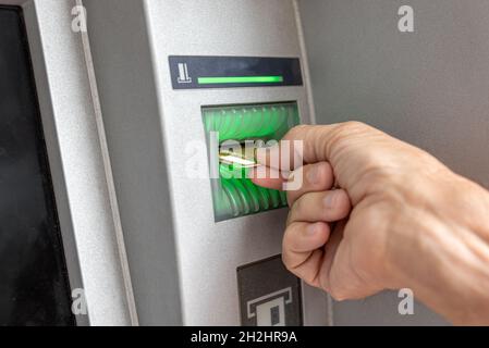 Male hand using credit card to withdraw money from ATM bank machine Stock Photo