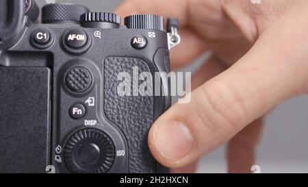 RUSSIA, MOSCOW-DECEMBER, 2020: Memory card in camera. Action. Close-up photographer inserts new memory card into camera. Replacing memory card in came Stock Photo