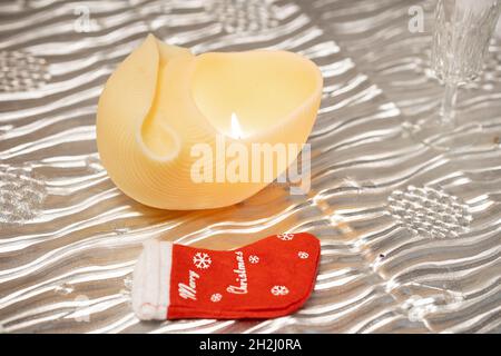 Christmas decorations. Traditional Christmas candle and merry Christmas socks. Stock Photo