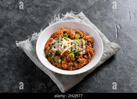 Keema curry in bowl over dark stone background. Indian and pakistani style dish. Stock Photo