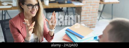 Young business woman explaining information to man with digital tablet in her hands Stock Photo