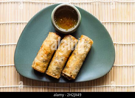 portion of fried Mon Nem, Vietnamese fried crispy spring rolls on green plate Stock Photo