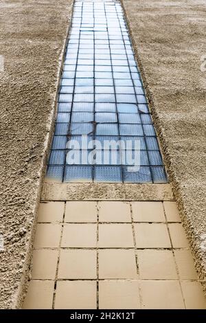 bottom view of rough plastered and painted wall of house with insert of glass blocks Stock Photo