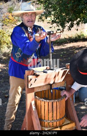 Volunteers demonstrate how American pioneers made apple cider with a cider press at El Rancho de las Golondrinas living history museum in New Mexico. Stock Photo