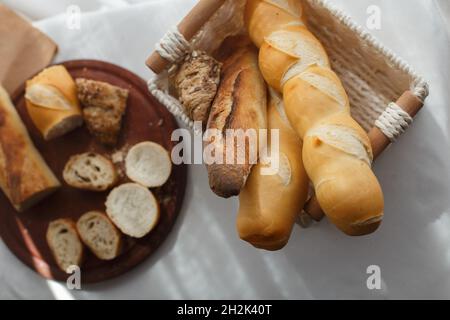 rye, wheat and multigrain baguettes in a wicker basket, top view Stock Photo