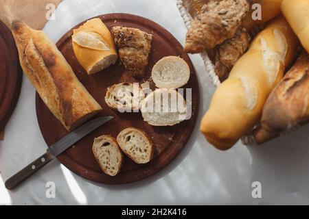 rye, wheat, multigrain baguettes in a basket, pieces on a wooden board Stock Photo