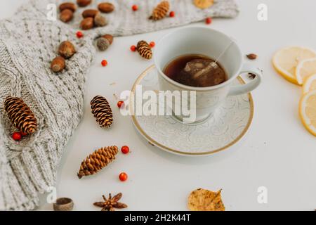 White and gold tea cup with tea bag on a white background with lemon Stock Photo