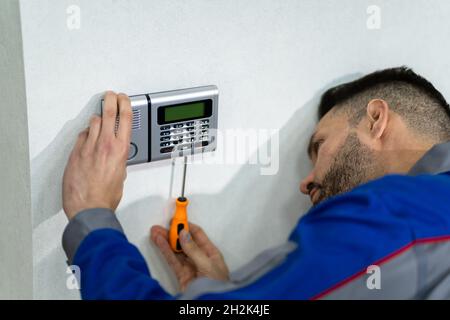Technician Installing Security Access Alarm System Control Stock Photo