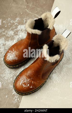 Boots with snow on two tone background. Stock Photo