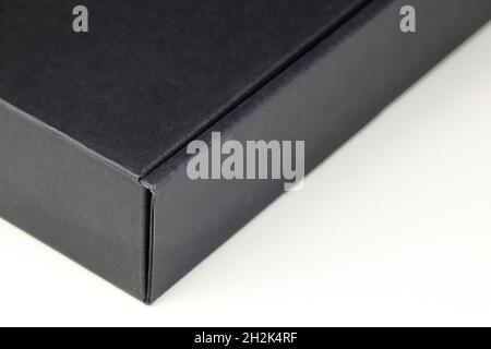 https://l450v.alamy.com/450v/2h2k4rf/right-corner-close-up-of-black-square-cardboard-box-for-parcel-delivery-isolated-on-white-background-2h2k4rf.jpg