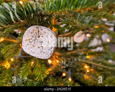 Modern handmade terrazzo christmas ball hanging in the christmas tree Stock Photo