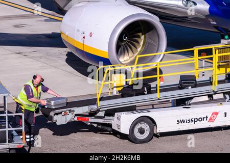 Ground crew load baggage onto a Ryanair jet on the apron at Edinburgh Airport, Edinburgh, Scotland, UK Stock Photo