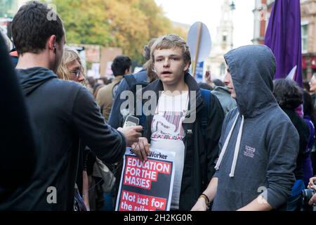 LONDON, ENGLAND - NOVEMBER 19 2017: Students take part in a protest march against fees and cuts in the education system . Young man holds a poster - E Stock Photo