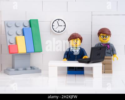 Tambov, Russian Federation - October 16, 2021 Two Lego businesswoman minifigures working on a laptop in their office with a graph showing their succes Stock Photo