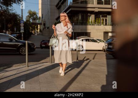 Young woman in glasses walking on the street Stock Photo