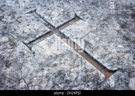 Christian cross emblem engraved in marble tombstone in a graveyard Stock Photo