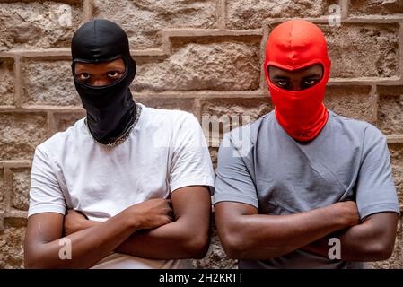 Two afro young men in ski masks in alleyway Stock Photo