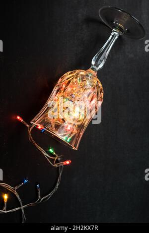 Colorfull christmas lights in a glass  cup on a black wooden table Stock Photo