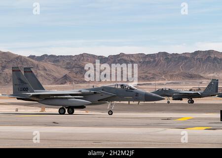 An F-15EX Eagle II Fighter Jet assigned to the 85th Test and Evaluation Squadron, Eglin Air Force Base, Florida, takes off and an F-15C Eagle assigned to the 123rd Fighter Squadron, Portland Air National Guard Base, Oregon, taxis to the runway at Nellis Air Force Base, Nevada, Oct. 20, 2021. Aircraft from Nellis AFB, Eglin AFB Florida, and the Oregon Air National Guard are providing support for the Test and Evaluation of the F-15EX in operationally realistic scenarios to determine how effective and suitable the aircraft is at accomplishing its air-to-air mission for future Air Force use. (U.S. Stock Photo