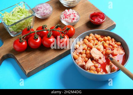 Bowl with homemade pozole soup and ingredients on color background Stock Photo