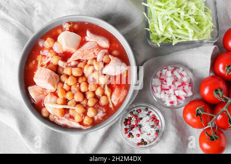 Tasty homemade pozole soup and ingredients on table Stock Photo